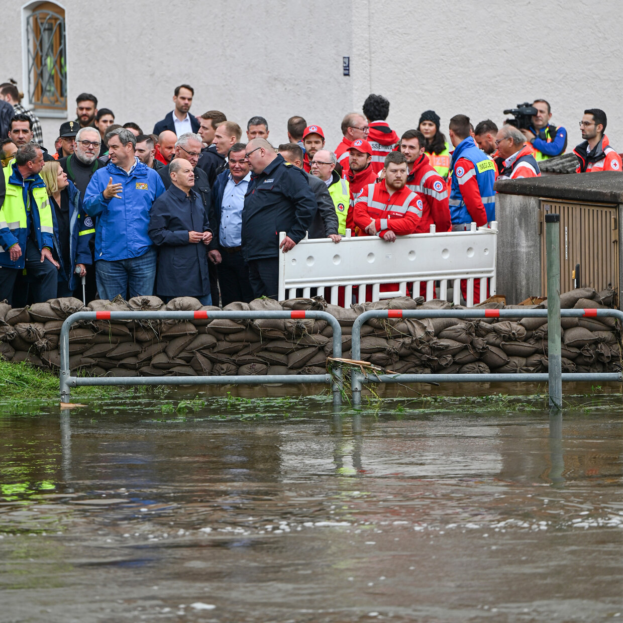 Scholz, Faeser, Söder und Herrmann beim Ortstermin in Reichertshofen hinter Sandsäcken vor Flut