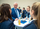 Herrmann im Gespräch mit neueingestellten Polizistinnen an Stehtisch