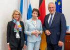 Andrea Breit, Präsidentin des Bayerischen Verwaltungsgerichtshofes, ehemalige Richterin, Dr. Ariane Wiedmann und Innenminister Joachim Herrmann vor Flaggen