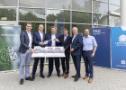 Gruppenbild mit Modell und Schlüssel, im Hintergrund FAU-Gebäude