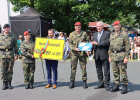 Herrmann und Personen von der Bundeswehr mit Ortsschild Weiden i.d.Opf. und Geschenken