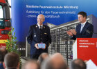 Dr. Demke mit Geschenk, daneben Kirchner applaudierend am Rednerpult
