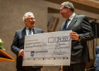 Innenminister Joachim Herrmann mit großem Scheck neben Vertreter der Bay. Polizeistiftung