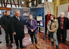 Innenminister Joachim Herrmann und weitere Personen vor Ausstellungstafel