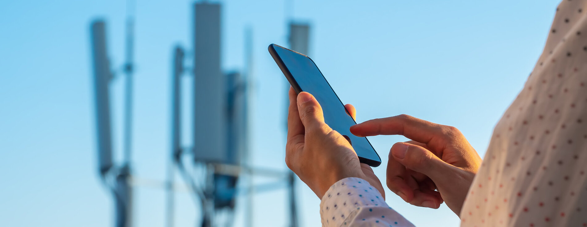Mit Hilfe der Cell-Broadcast-Technologie können sogenannte „Warn-SMS“ direkt an alle Menschen mit einem empfangsbereiten Mobilfunkgerät versendet werden, die sich in einer Gefahrenzone befinden. Mann seitlich mit Handy in der Hand