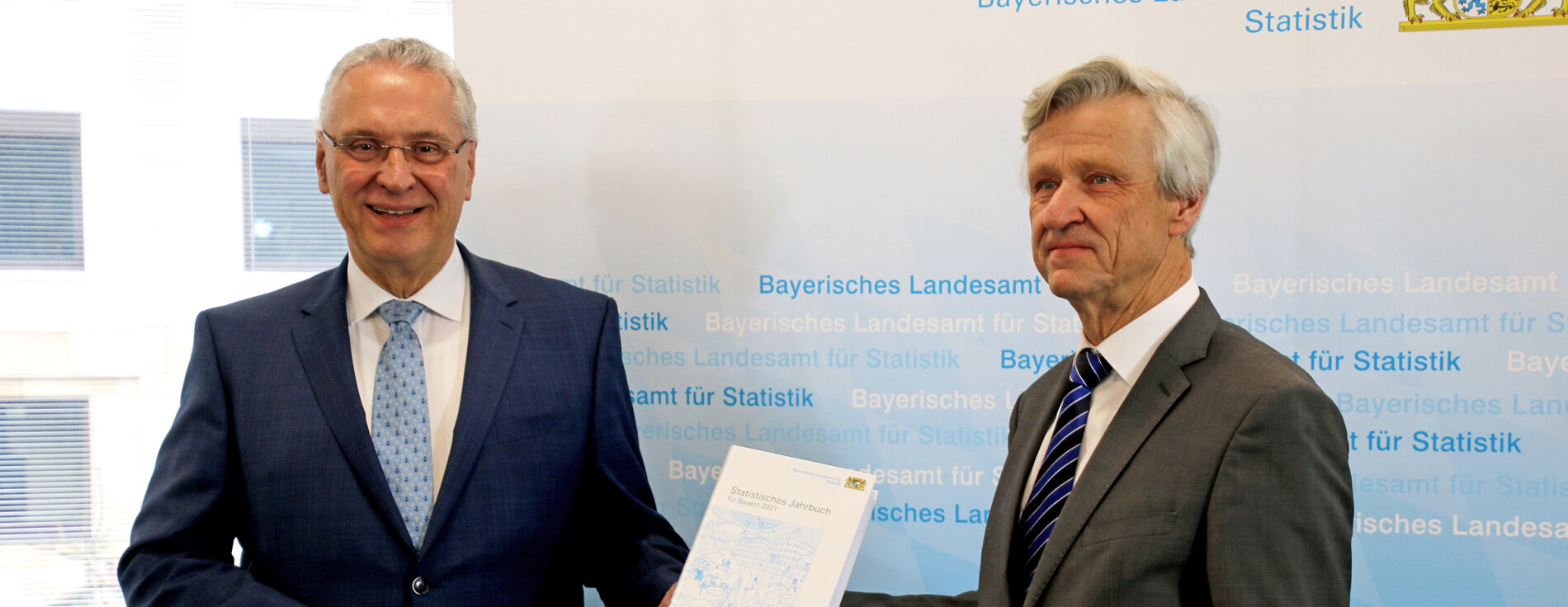 Innenminister Joachim Herrmann mit statistischem Jahrbuch in der Hand und Präsident des Landesamtes für Statistik Dr. Thomas Gößl