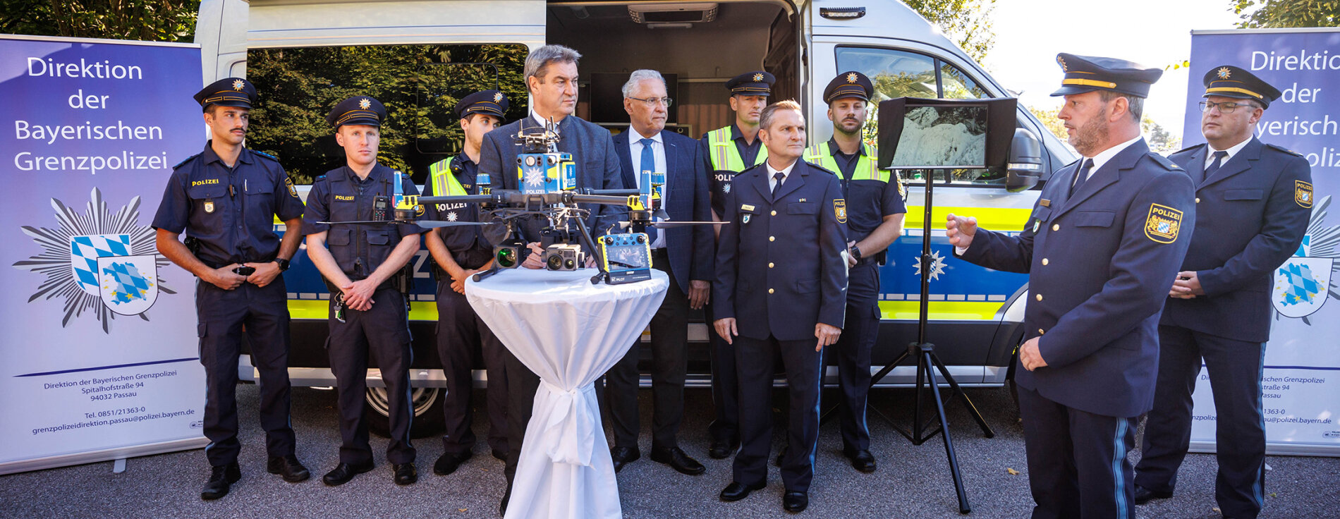 20. September 2023: Mehr Sicherheit durch verstärkten Grenzschutz: Bayerns Ministerpräsident Dr. Markus Söder und Innenminister Joachim Herrmann kündigen an einer Kontrollstelle bei Freilassing den weiteren Ausbau der Bayerischen Grenzpolizei an. Söder: „Solange die EU-Außengrenzen nicht effektiv geschützt werden, müssen wir unsere eigenen Grenzen sichern.“ Herrmann ergänzte: „Die Bayerische Grenzpolizei leistet seit mehr als fünf Jahren eine hervorragende Arbeit. Unsere Grenzfahnderinnen und Grenzfahnder werden künftig für noch mehr Sicherheit sorgen.“ Söder und Herrmann bei Pressekonferenz vor Polizeiauto mit Grenzpolizisten in Uniform. Im Vordergrund Polizeidrohne
