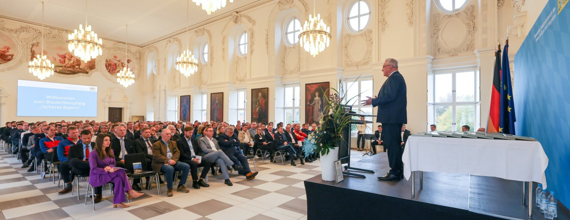 19. Oktober 2024: Beim Blaulichtempfang 'Sicheres Bayern' in der Hochschule für den öffentlichen Dienst in Bayern in Fürstenfeldbruck hat Herrmann 15 verdiente Arbeitgeber aus ganz Bayern mit der Auszeichnung ‚Ehrenamtsfreundlicher Betrieb – Gemeinsam für mehr Sicherheit‘ geehrt: „Schutz und Hilfe für die Bevölkerung zu jeder Tages- und Nachtzeit kann es nur geben, wenn hinter den vielen ehrenamtlichen Helferinnen und Helfern Arbeitgeber stehen, die ihnen trotz möglicher Auswirkungen auf den Betriebsablauf den Rücken freihalten. Ich spreche Ihnen mit dieser Auszeichnung meine Anerkennung und meinen Dank für diese herausragende Unterstützung des sicherheitsrelevanten Ehrenamts aus.“ Blick in den Saal mit Publikum und Innenminister Herrmann auf Bühne am Rednerpult
