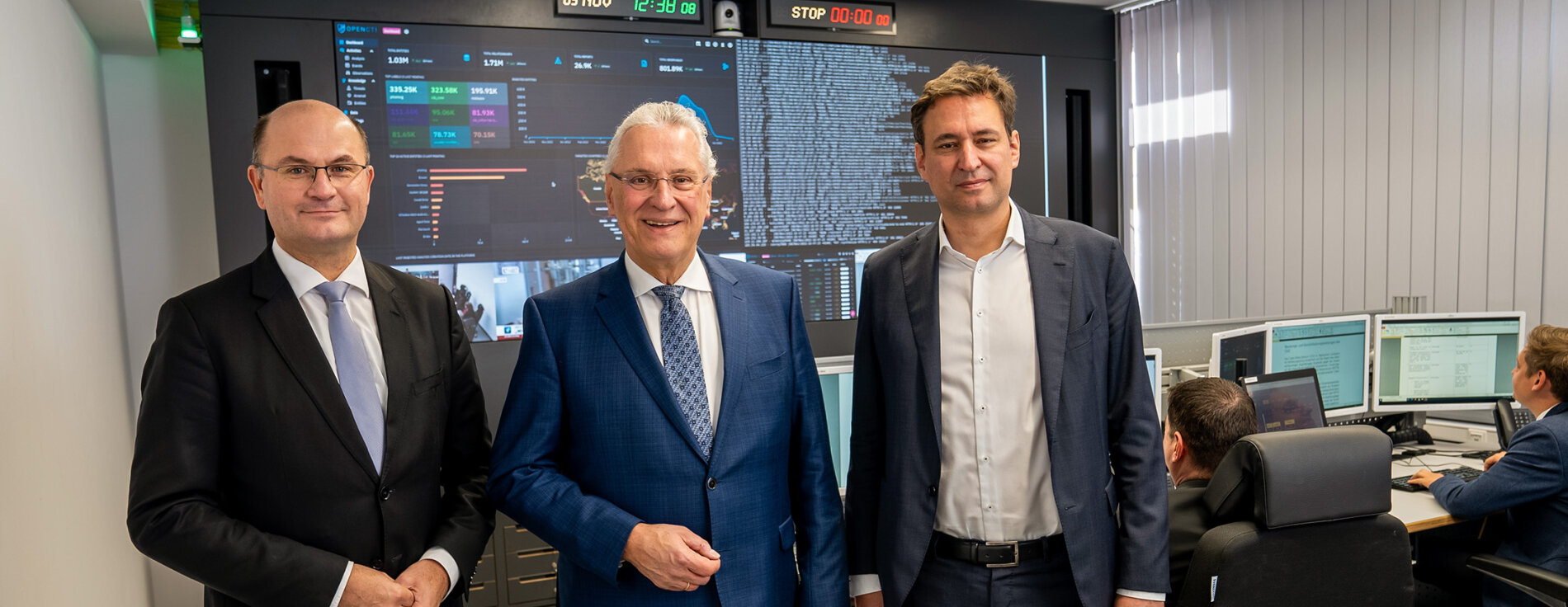 Innenminister Joachim Herrmann, Finanzminister Albert Füracker und Justizminister Georg Eisenreich im Cyber-Lagezentrum, im Hintergrund Arbeitsplätze mit vielen Monitoren