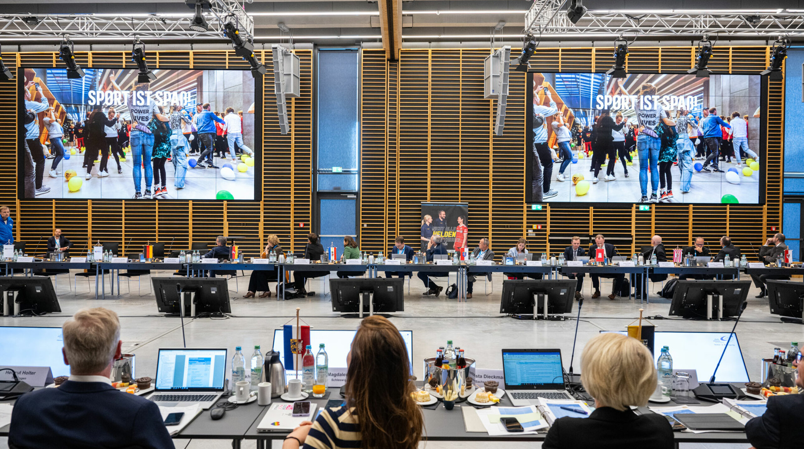 Plenum der Sportministerkonferenz. Monitor: "Sport ist Spaß"