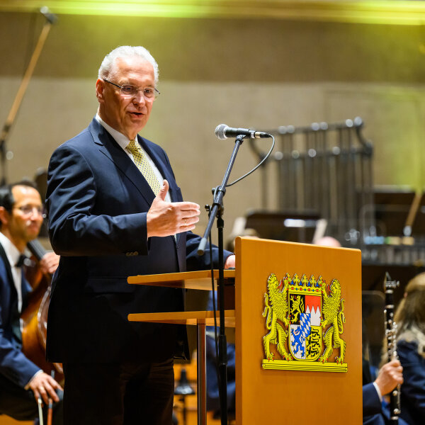 Innenminister Joachim Herrmann am Rednerpult vor Orchester