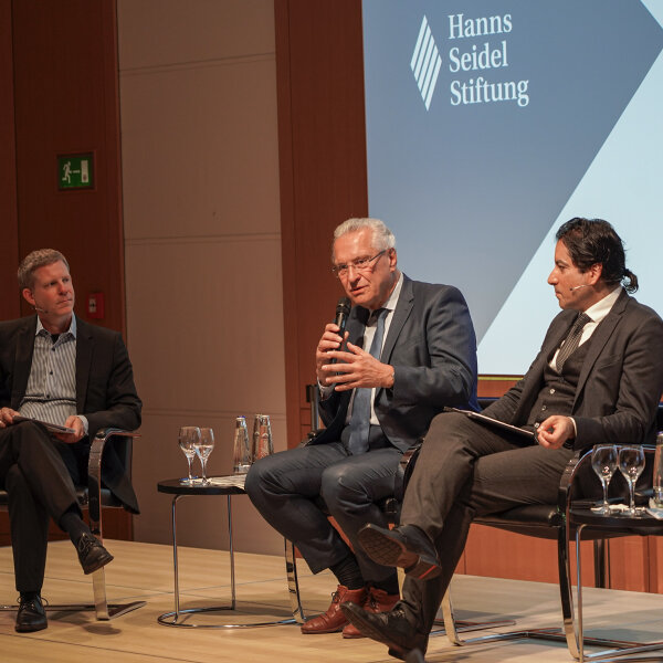 Herrmann mit Mikrofon bei Podiumsdiskussion