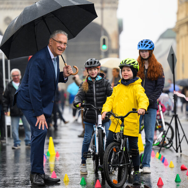 Innenminister Joachim Herrmann neben Kindern auf Fahrradparcour