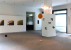 Blick in den Ausstellungsraum im Foyer der Obersten Baubehörde: Auf der Rückwand Fotoarbeiten von Klaus von Gaffron, links Installation 'Pralinés I-III' von Gregor Passens, hängend Raumobjekt von Katharina Weishäupl