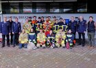 Gruppenbild mit Feuerwehrleuten und Schülern in Einsatzkleidung