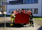 Schüler in Einsatzkleidung schieben einen Anhänger