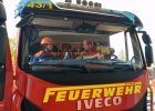 Junge Feuerwehrfrau und Feuerwehrmann in Feuerwehrauto