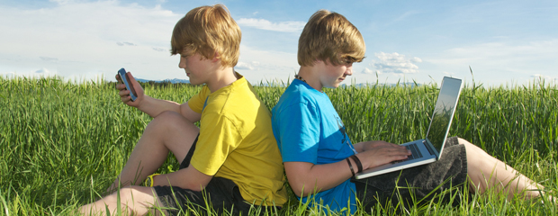 Die Polizei berät Kids und Teens über den sicheren Umgang mit Handys und Computern. Zwei Kinder mit Handy und Laptop