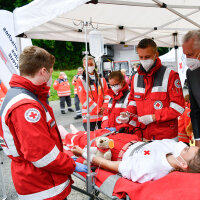 30. August 2021: Innenminister Joachim Herrmann konnte sich heute beim Rundgang durch die verschiedenen Stationen der Bereitschaften des BRK zahlreiche Eindrücke über die Bandbreite an Aufgaben verschaffen: „Es ist beruhigend zu wissen, dass es in Bayern ein so starkes Netzwerk aus Hilfsorganisationen, Feuerwehren, Technischem Hilfswerk, Bundeswehr, Bundespolizei und unserer Bayerischen Polizei gibt. Auf die enge, schnelle und vertrauensvolle Zusammenarbeit der Blaulichtorganisationen untereinander, aber auch mit den Integrierten Leitstellen, ist Verlass.“ Innenminister Joachim Herrmann und BRK-Einsatzkräfte mit Blick auf eine Trage