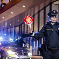 Polizeibeamtin mit Polizeikelle
