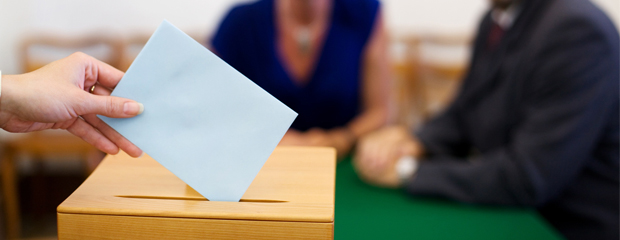 Einwurf eines Stimmzettels in die Wahlurne Einwurf eines Stimmzettels in die Wahlurne